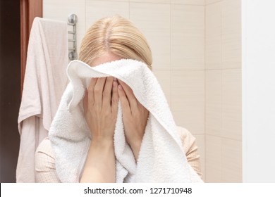 Woman Drying And Cleaning Her Face With A White Towel.