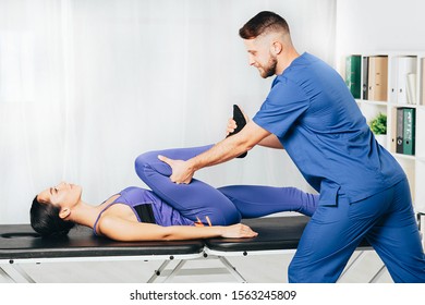 woman during exercises with her physiotherapist treating back and joint pain
