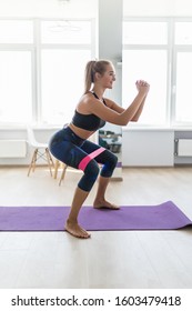 Woman During Her Fitness Workout At Home With Rubber Resistance Band