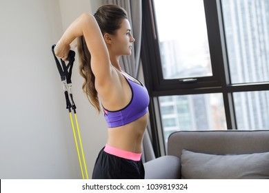 Woman during home workout with a rubber resistance bands