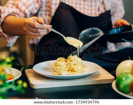 The woman during make the spaghetti food in the kitchen