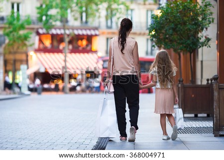 Woman during the shopping with the little adorable girl in Paris outdoors