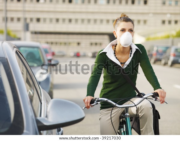 woman with dust mask\
commuting on bicycle