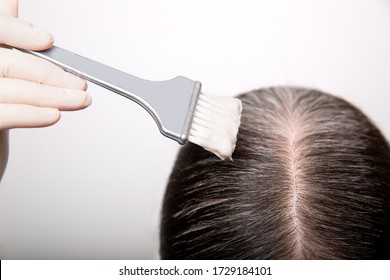 Woman Dyeing Grey Hair Root With Brush And Hair Color, Close Up