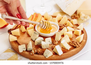 Woman Eat Big Italian Cheese Board Gourmet Food With Honey Side View. Girl Taste French Cheeseboard With Brie, Parmesan And Mozzarella Assorted. Blue Cheddar, Gouda And Walnut Various Dessert Platter