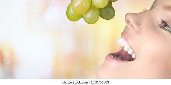 Woman eat Tasty Grapes on sunny background - Powered by Shutterstock