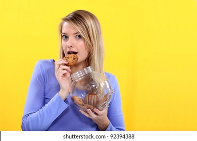 Woman Eating Biscuit From Jar