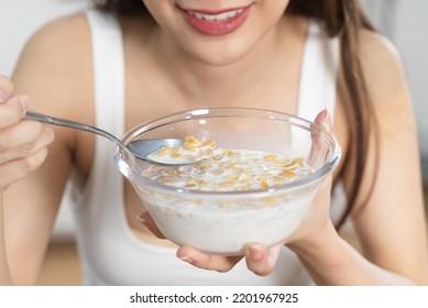 Woman Eating A Bowl Of Cereal With Milk As Breakfast In Morning