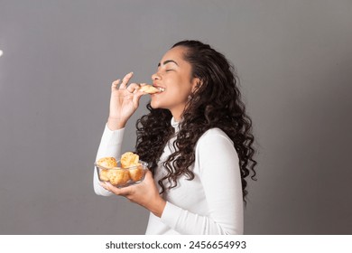 Woman eating cheese bread, typical food from Minas Gerais state of Brazil. Woman eating cheese bread or chepa - Powered by Shutterstock