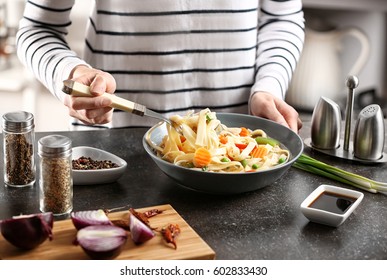 Woman Eating Chicken Noodle Soup At Kitchen Table