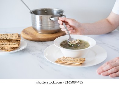 Woman Eating Chicken Soup With Vegetables In A White Plate With A Spoon