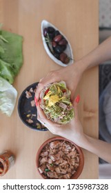 Woman Eating A Chicken Wrap Holding It With Both Hands At Home. Fresh Lettuce Wraps Delicious Option For Lunch Or Dinner. Healthy Lettuce