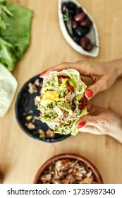 Woman Eating A Chicken Wrap Holding It With Both Hands At Home. Fresh Lettuce Wraps Delicious Option For Lunch Or Dinner. Healthy Lettuce
