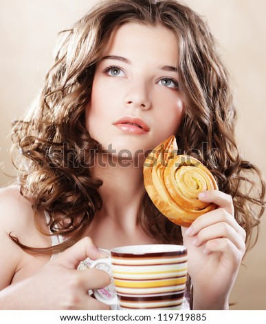Woman eating cookie and drinking coffee. Cute adorable beautiful young female model.