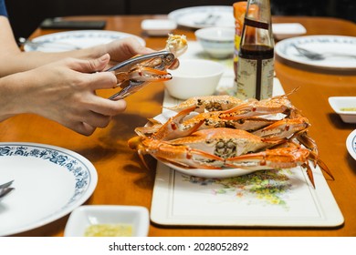 Woman Eating Crab Claw Using Special Pliers Tool