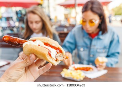 Woman Eating Currywurst Fast Food German Sausage In Outdoor Street Food Cafe