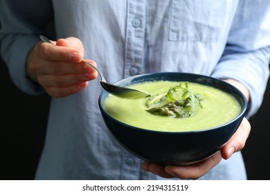 Woman Eating Delicious Asparagus Soup On Black Background, Closeup