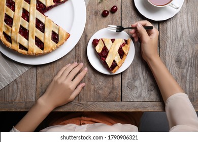 Woman Eating Delicious Cherry Pie At Wooden Table, Top View