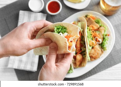 Woman Eating Delicious Fish Taco In Kitchen