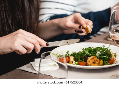 woman eating delicious salad with shrimp in a restaurant - Shutterstock ID 617520584