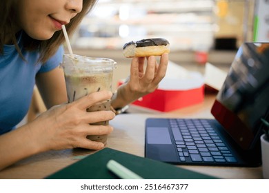 Woman eating donuts and working on tablet at cafe - Powered by Shutterstock