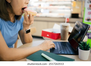 Woman eating donuts and working on tablet at cafe - Powered by Shutterstock