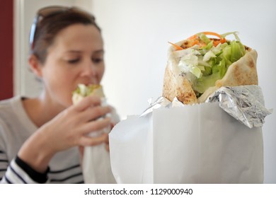 Woman Eating Falafel Warp. Food Background And Texture.