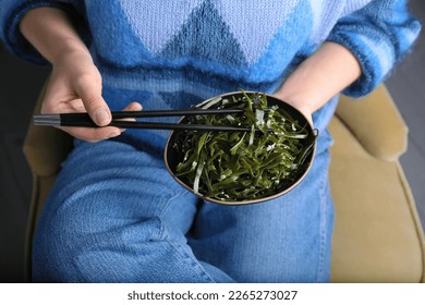 Woman eating fresh laminaria (kelp) seaweed, closeup - Shutterstock ID 2265273027