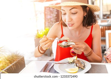 Woman Eating Fresh Oyster In Seafood Mediterranean Restaurant