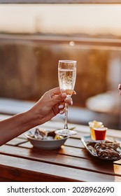 Woman Eating Fresh Oysters And Drinking Chilled Prosecco Wine On The Summer Sunset. Seafood Delicacies