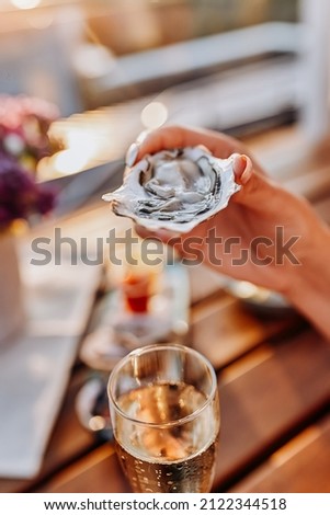 Woman eating fresh oysters and drinking chilled prosecco wine on the summer sunset. Seafood delicacies ストックフォト © 