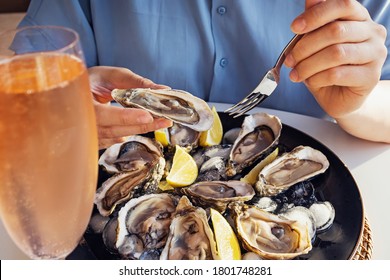 Woman eating fresh oysters with lemon close-up