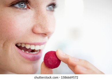 A Woman Eating A Fruit Flavored Chocolate Truffle