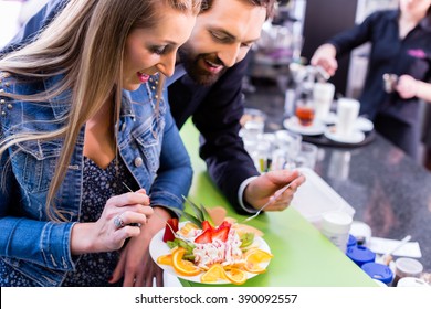 Woman Eating Fruit Sundae In Ice Cream Cafe