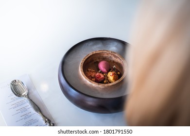 Woman Eating A Gourmet Sorbet Dessert Decorated With Dry Ice Smoke Effect. Dry Ice Food Decorations In A High End Gourmet Restaurant