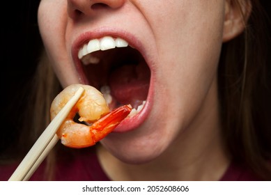 Woman Eating Grilled Shrimp With Chopsticks. Asian Cuisine. Wide Open Mouth And Big Tasty Shrimp. 