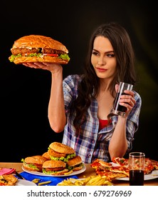 Woman Eating Hamburger. Student Consume Fast Food. Girl Bite Of Very Big Burger. Girl Trying To Eat A Lot Of Junk. Advertise Fast Food On Black Background. Girl Eat Up After A Diet.