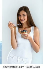 Woman Eating Healthy Diet Food. Portrait Of Beautiful Happy Young Female Holding Glass Of Natural Yogurt, Berries And Oats. Smiling Girl Having Yoghurt Oatmeal Dessert For Breakfast. High Resolution