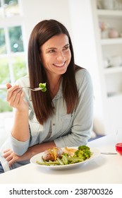 Woman Eating Healthy Meal In Kitchen