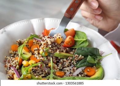 Woman Eating Healthy Quinoa Salad With Vegetables From Plate, Closeup