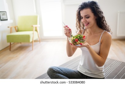 Woman Eating Healthy Salad After Working Out At Home