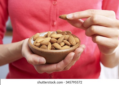 Woman Eating Healthy Snack Of Almonds