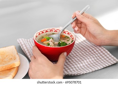 Woman Eating Homemade Chicken Soup On Table