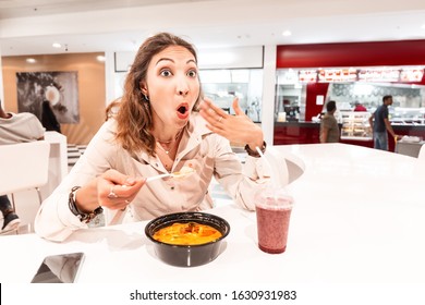 A Woman Eating Too Hot And Peppery Soup In An Asian Fast Food Restaurant. Concept Of Spices In Oriental Cuisine