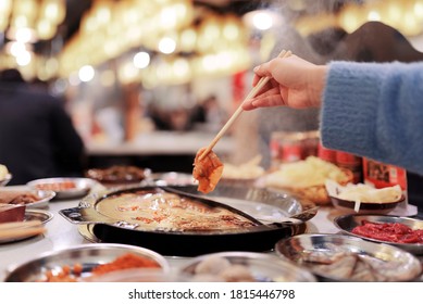 Woman Eating Hot Pot at restaurant.Chinese food.