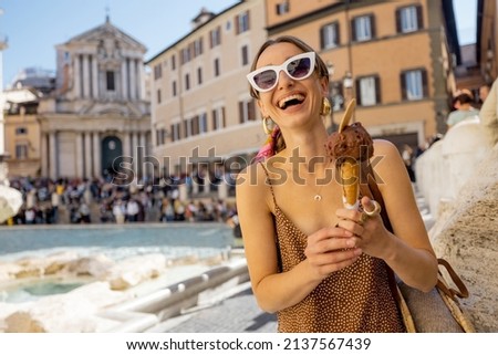 Woman eating ice cream in cone while visiting famous di Trevi fountain in Rome. Concept of happy summer vacations, traveling famous italian landmarks