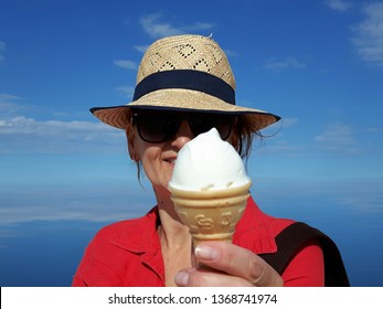 Woman eating ice-cream in summer by the sea