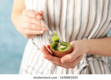 Woman Eating A Kiwi With A Spoon, Close Up