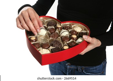 A Woman Eating A Piece Of Chocolate Out Of A Heart Shaped Valentines Box