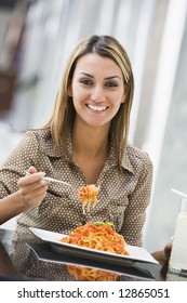 Woman Eating Plate Of Pasta At Cafe